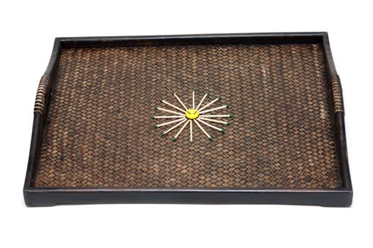 Yellow smile with match on bamboo tray around, on white background