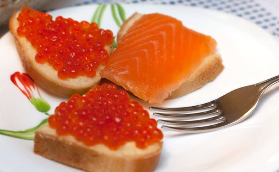 Sandwiches with red roe on white plate, salmon