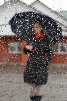 Beautiful girl with red scarf and umbrella for glass with drop of water
