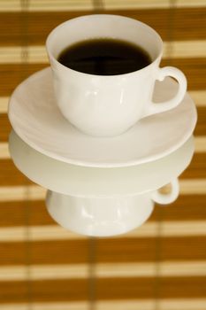 A rich cup of hot coffee, with fresh roasted beans