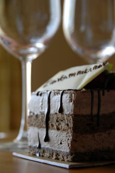 chocolate pastry cake with congratulations greeting and Wine Glasses