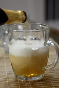 isolated shot of beer poured in a glass from a bottle