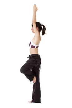 Young woman doing yoga excise by standing on one foot isolated over white.