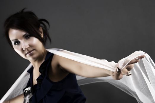 Portrait of a young beautiful brunette holding her sheer scarf