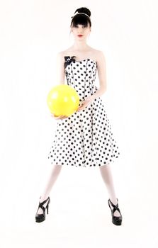 Portrait of a young beautiful brunette posing with yellow ball