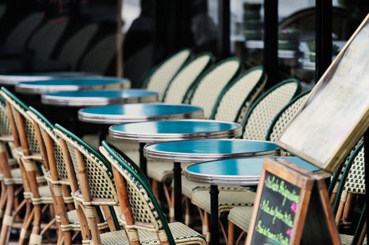 Round tables and wicker chairs in cafe in Paris. Photo with tilt-shift effect