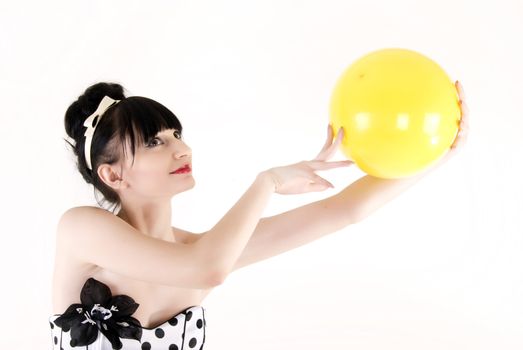 Portrait of a young beautiful brunette posing with yellow ball