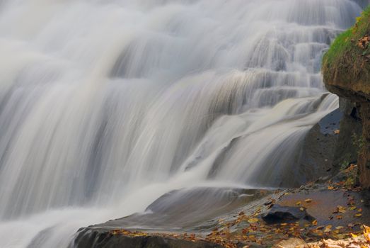 Water gushing thru a snowy waterfall during autumn