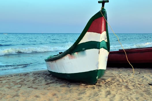 A fishing boat parked by the sea shore