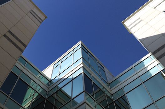 Modern geometric skyscrapers against a clear blue sky