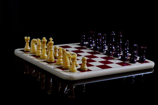 Chess board and coins isolated on a black background