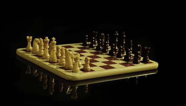 Chess board and coins isolated on a black background