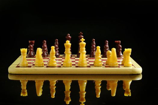 Chess board and coins isolated on a black background