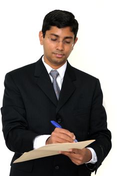 An handsome Indian businessman signing some documents
