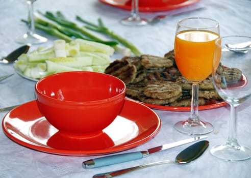 red plates and orange juice served on table in kitchen