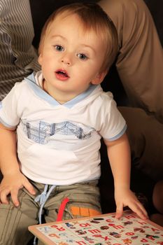 Photo of small boy with book in studio