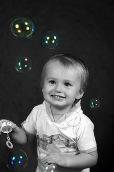 The small boy with soap bubbles in studio