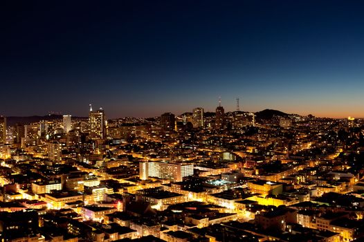 A view of a city at night with a sunset on the horizon - San Jose