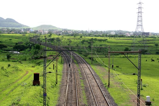 Rail tracks on lush green countryside in India.