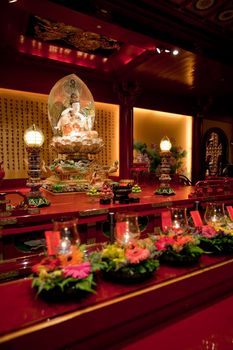 An interior of a Buddhist temple with a Buddha statue