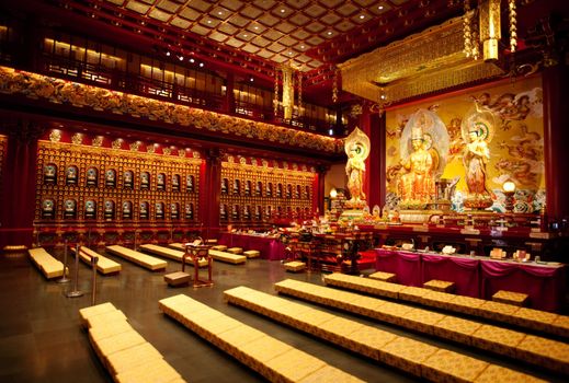 An interior of a Buddhist temple with a Buddha statue