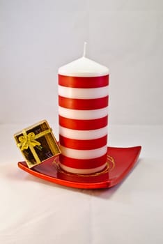 Red and white candle with golden gift box