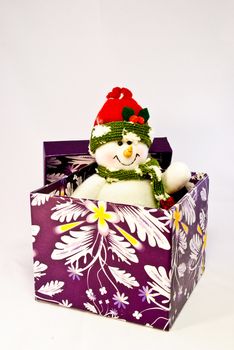 A toy snowman popping out of a  purple box