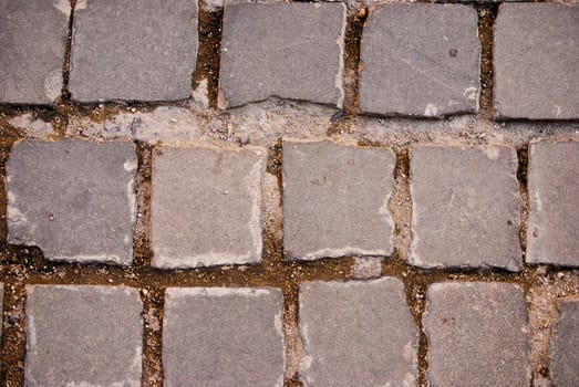 Grey square tiles of pavement forming a pattern