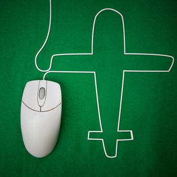 An computer mouse and airplane concept - booking a flight online