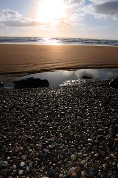 a pebble beach near ballybunion in county kerry ireland at sunset