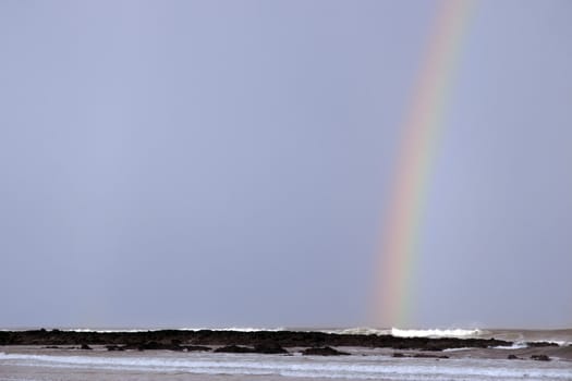 ballybunion beach and rocks with rainbow as a storm passes