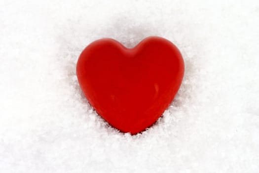 Red stone heart in artificial snow