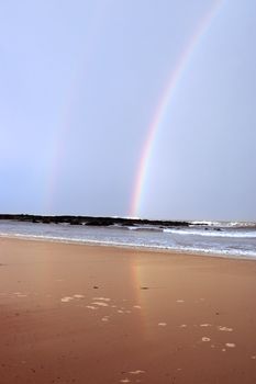 ballybunion beach and rocks with twin rainbows as a storm passes