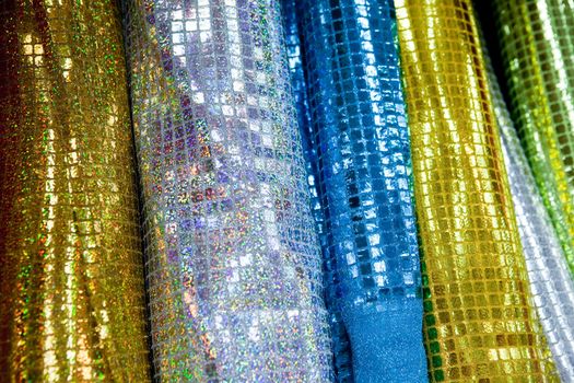 A background of various rolls of sparkly cloth