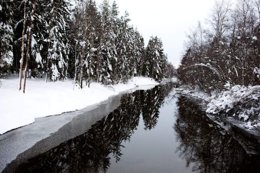 A cold winter river with a grey sky