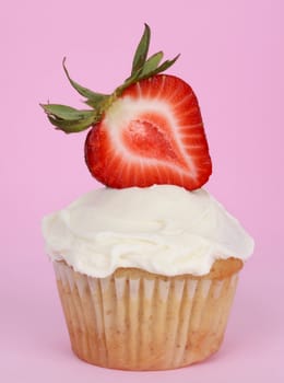 cupcake with white icing and slice of strawberry