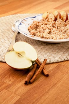 Apple Cinnamon Porridge - shallow depth of field with focus on the apple and cinnamon stick