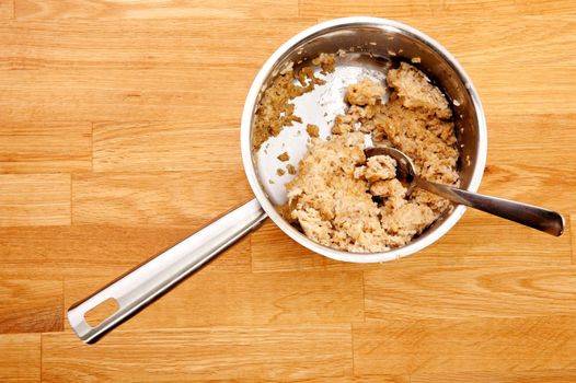 A pot of old cold porridge on a wooden table