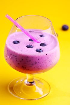 A delicious blueberry smoothie isolated on yellow