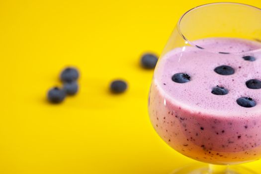 A delicious blueberry smoothy isolated on yellow