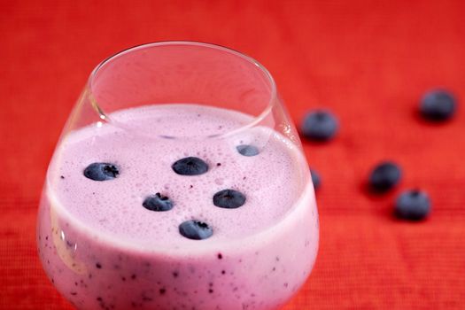 A delicious blueberry smoothie on a red background