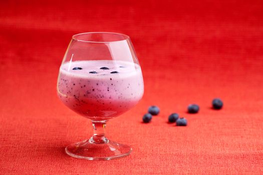 A delicious blueberry smoothie on a red background