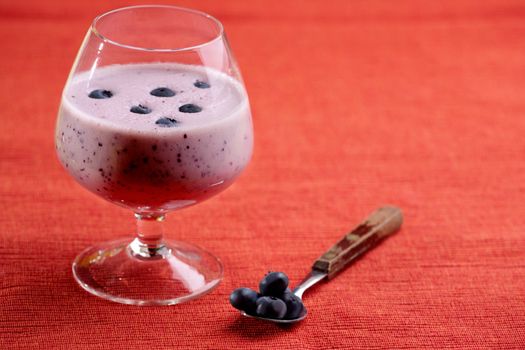 A delicious blueberry smoothie over a red cloth background