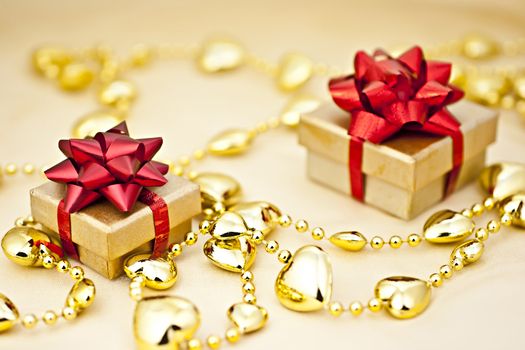 On the golden background gift box with a golden heart strings.

