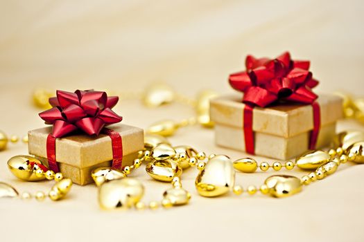 On the golden background gift box with a golden heart strings.