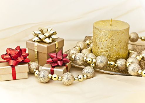 The gold background with a Christmas candle ball chains and gift boxes.
