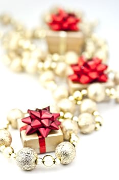 On a white background golden gift box with red tassels of golden ball chain.
