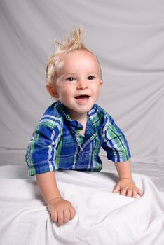 Portrait of a toddler boy with spiked hair, looking happy and smiling