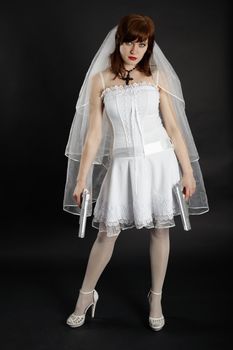 The bride in white dress armed with two pistols on dark background