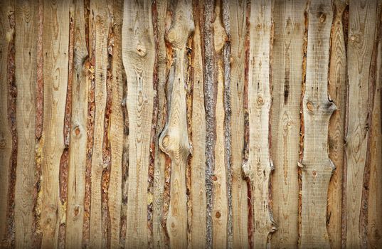 Coarse rural wooden fence made of boards and slabs - the background